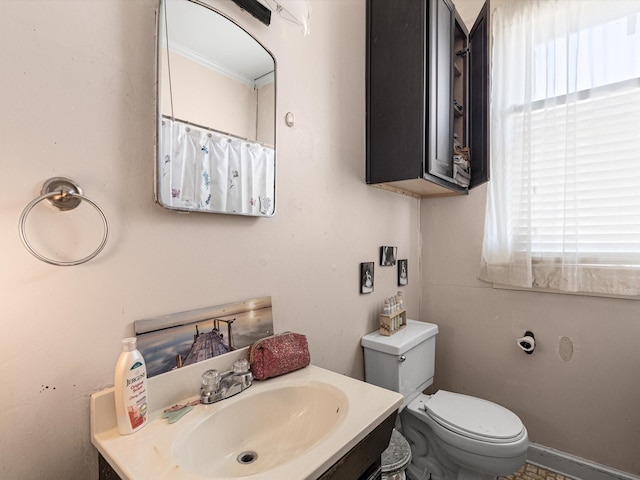 bathroom with vanity, plenty of natural light, ornamental molding, and toilet