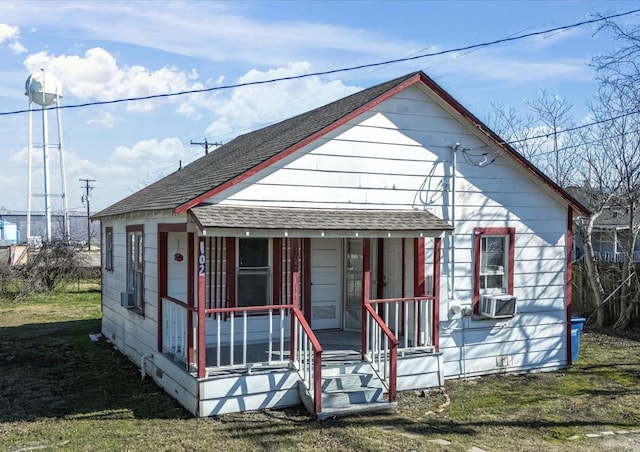 view of front of property featuring a porch, cooling unit, and a shingled roof