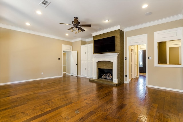 unfurnished living room featuring crown molding, a brick fireplace, ceiling fan, and dark hardwood / wood-style flooring