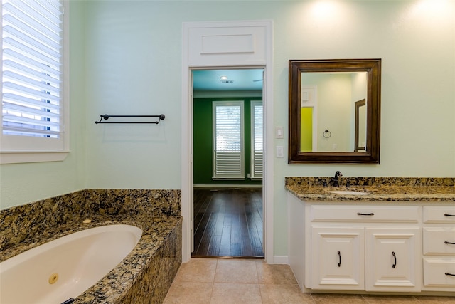 bathroom featuring vanity, tile patterned floors, and a tub