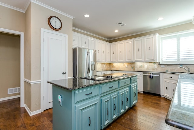 kitchen with white cabinetry, sink, stainless steel appliances, and a kitchen island