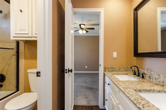 full bathroom featuring bath / shower combo with glass door, ornamental molding, vanity, ceiling fan, and toilet