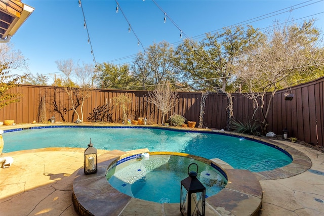 view of swimming pool featuring an in ground hot tub and a patio