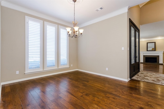 spare room with ornamental molding, dark hardwood / wood-style floors, and a notable chandelier