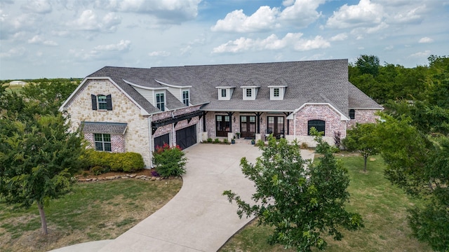 view of front of home featuring an attached garage, a shingled roof, concrete driveway, and a front yard