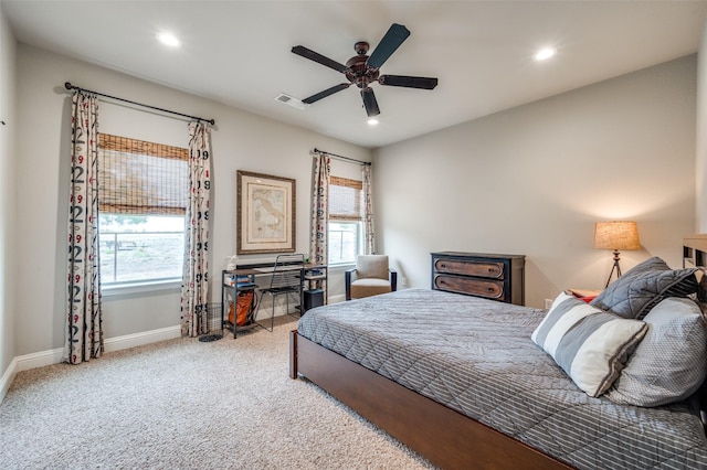 carpeted bedroom featuring multiple windows and ceiling fan