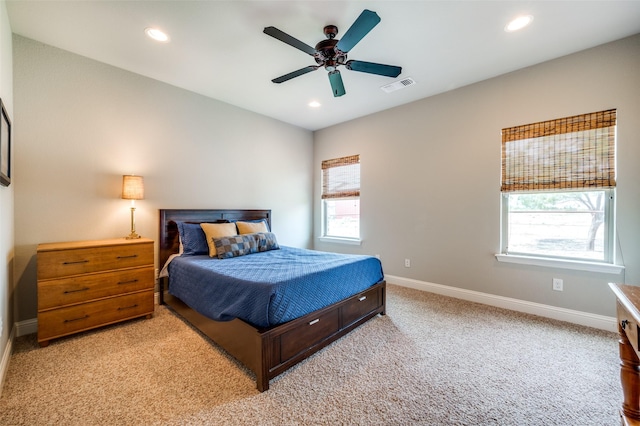 bedroom featuring multiple windows, light carpet, and ceiling fan