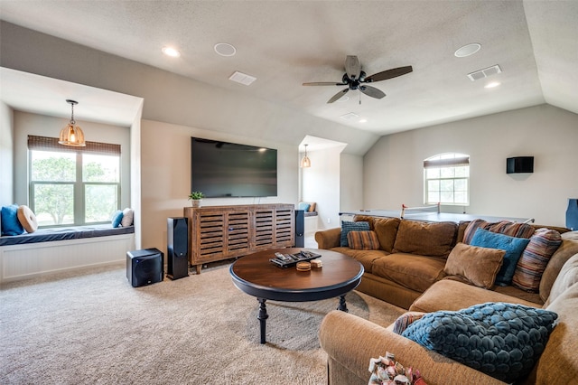 carpeted living room with lofted ceiling, ceiling fan, and a textured ceiling