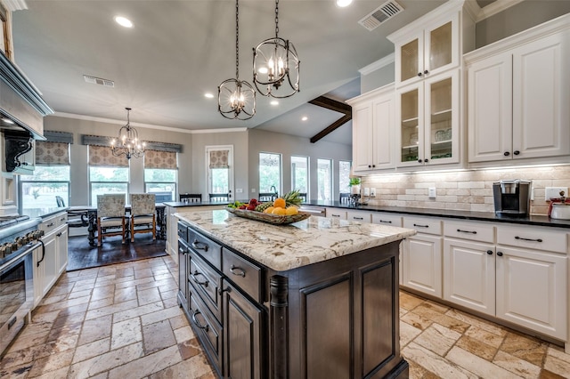 kitchen with tasteful backsplash, crown molding, decorative light fixtures, appliances with stainless steel finishes, and white cabinets