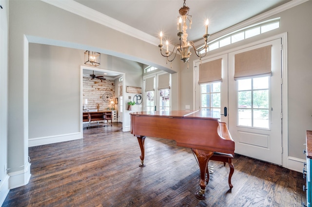 miscellaneous room with ornamental molding, dark wood-type flooring, an inviting chandelier, and french doors