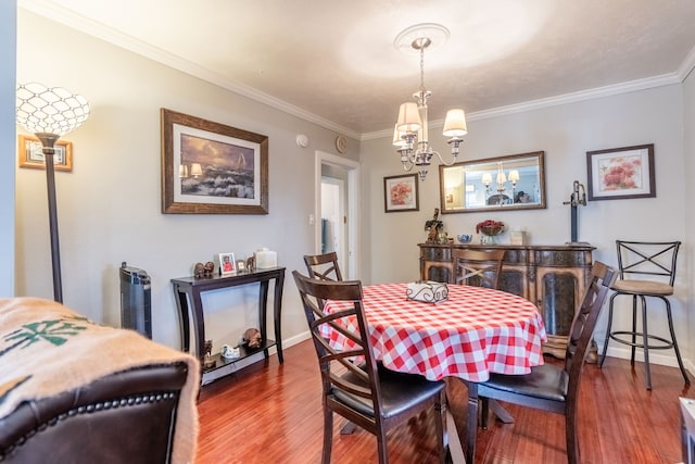 dining area featuring ornamental molding, a chandelier, and hardwood / wood-style floors