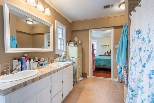 bathroom with crown molding, tile patterned floors, and vanity