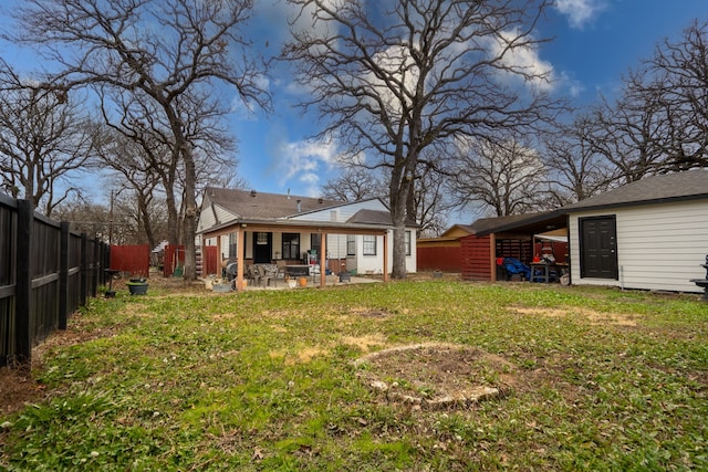 back of house with a patio area and a lawn