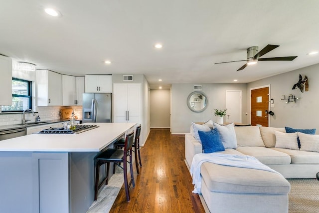 living room featuring dark hardwood / wood-style flooring, sink, and ceiling fan