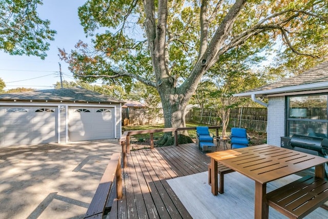 deck with a grill, a garage, and an outdoor structure