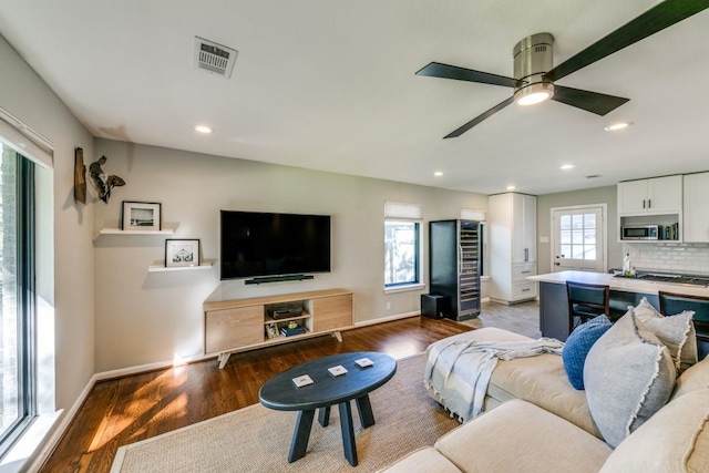 living room with ceiling fan and dark hardwood / wood-style floors