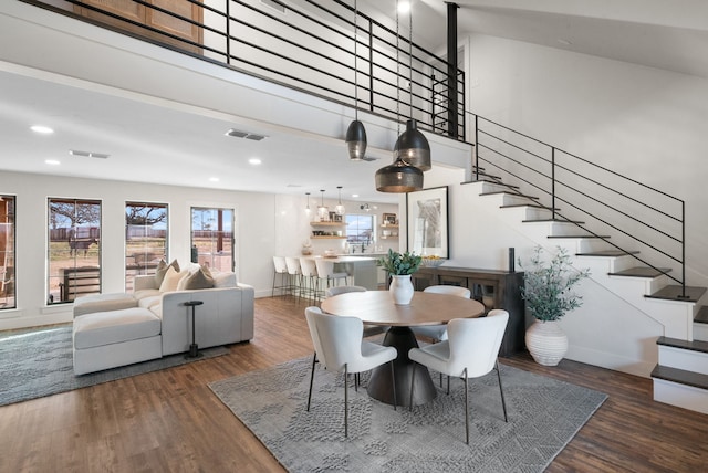 dining space featuring a high ceiling and dark hardwood / wood-style floors