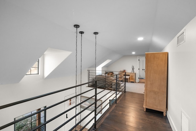 corridor with vaulted ceiling and dark wood-type flooring