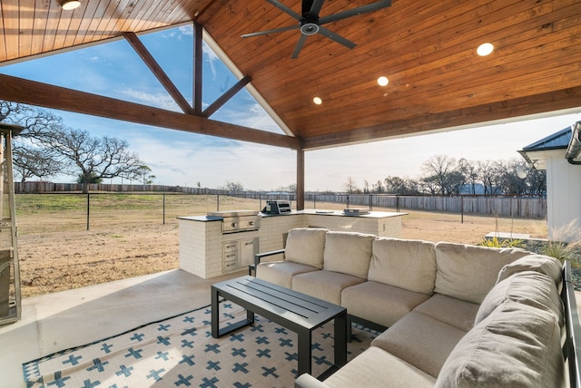 view of patio featuring an outdoor kitchen, grilling area, ceiling fan, an outdoor hangout area, and a rural view