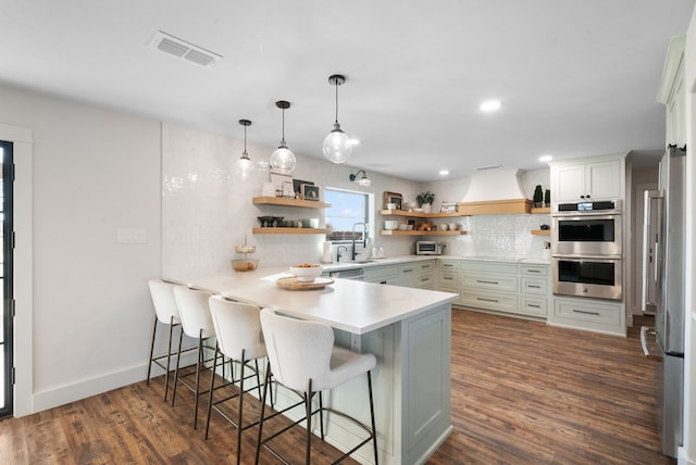 1252 Harmony Cir, Weatherford, TX 76087 - kitchen featuring open shelves, appliances with stainless steel finishes, a peninsula, dark wood finished floors, and recessed lighting