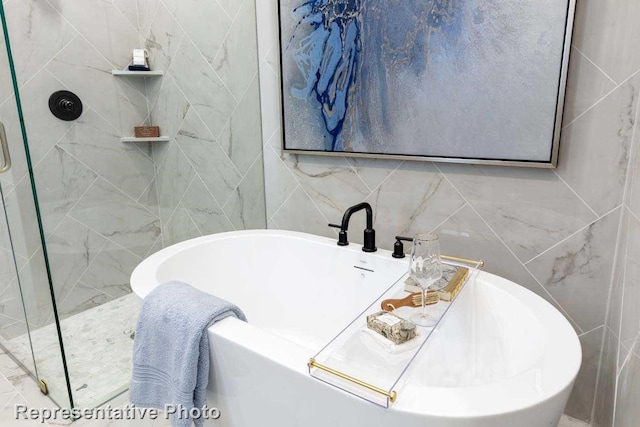 bathroom with independent shower and bath and tile walls