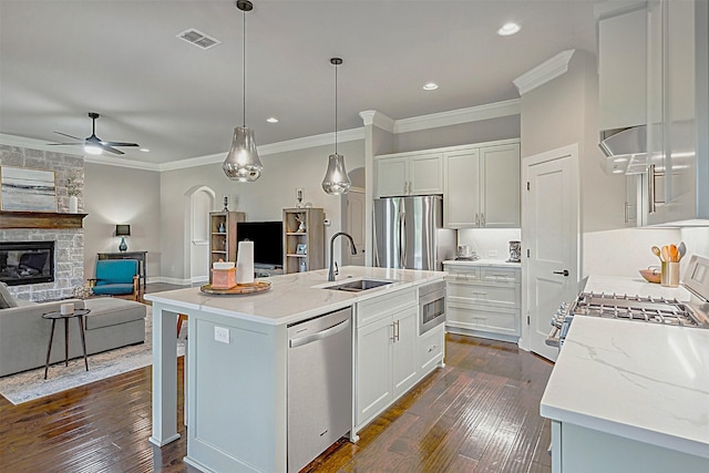 kitchen featuring stainless steel appliances, sink, an island with sink, and white cabinets