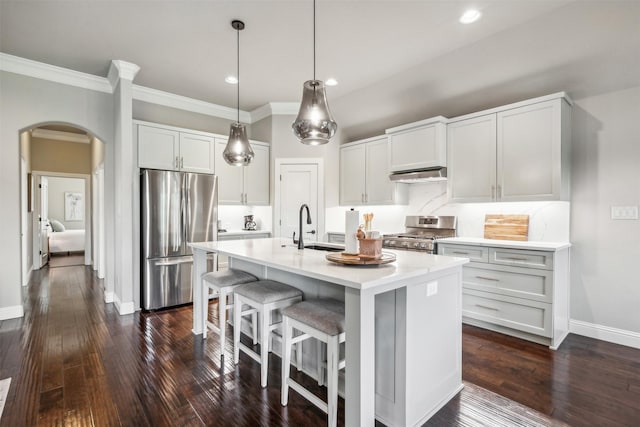 kitchen featuring sink, a breakfast bar area, appliances with stainless steel finishes, white cabinetry, and a center island with sink