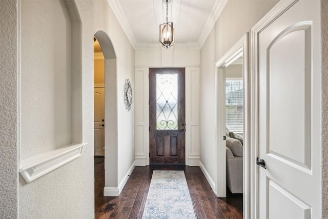 foyer with ornamental molding and dark hardwood / wood-style flooring