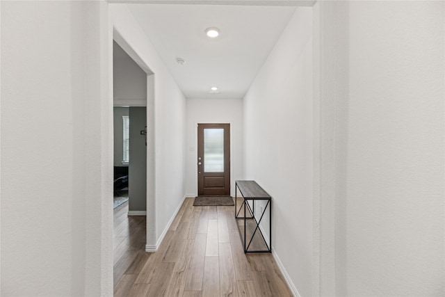 corridor with light hardwood / wood-style floors