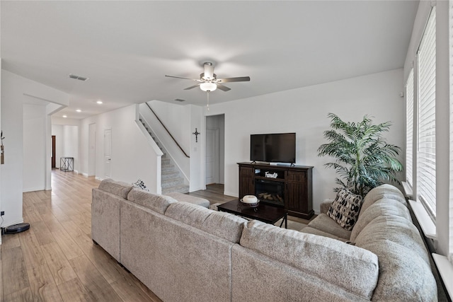 living room featuring wood-type flooring and ceiling fan