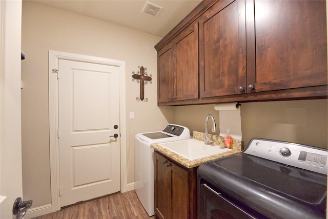 laundry room featuring cabinets, dark hardwood / wood-style flooring, sink, and independent washer and dryer