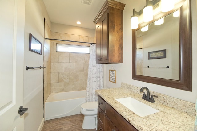 full bathroom with shower / tub combo, vanity, wood-type flooring, and toilet