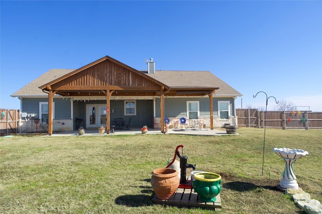 rear view of property featuring a yard and a patio area