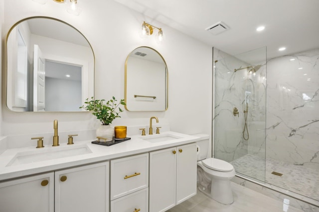 bathroom featuring a tile shower, vanity, and toilet