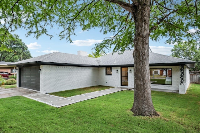 ranch-style house featuring a garage and a front lawn