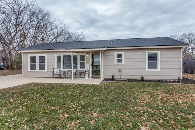 rear view of property with a yard and a patio area