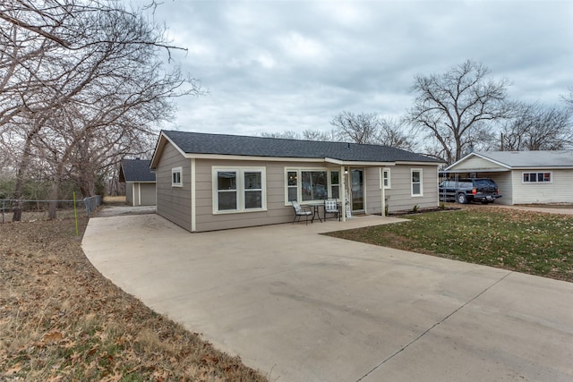 ranch-style home featuring a garage, an outbuilding, and a front yard