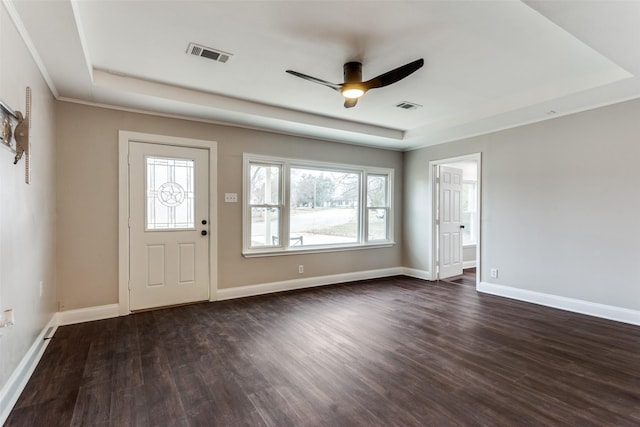 entrance foyer featuring ceiling fan, a tray ceiling, and dark hardwood / wood-style flooring