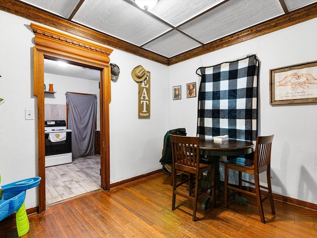 dining space with crown molding and wood-type flooring