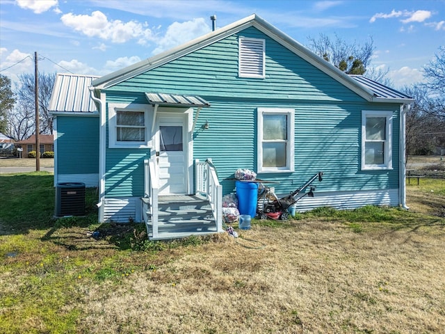 rear view of house featuring a yard and central air condition unit