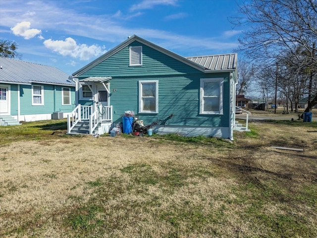 rear view of house with a yard and central air condition unit