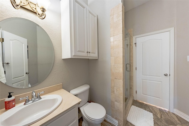 bathroom with vanity, toilet, and a shower with shower door