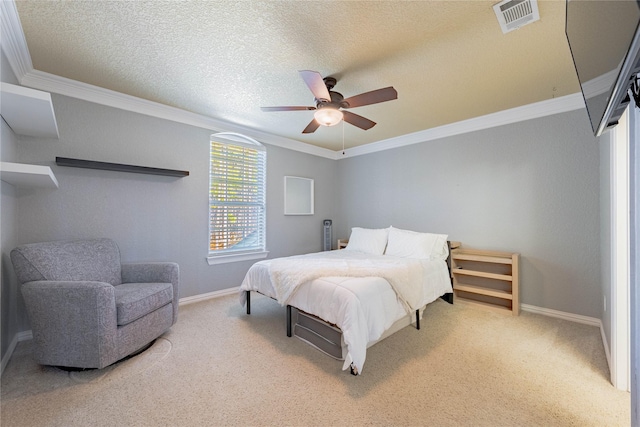 bedroom with crown molding, carpet floors, and a textured ceiling