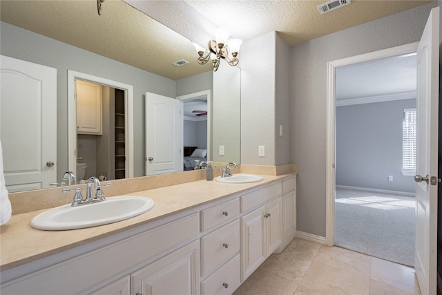 bathroom featuring tile patterned floors, toilet, an inviting chandelier, a textured ceiling, and vanity