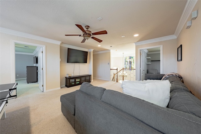 living room with ceiling fan, light colored carpet, ornamental molding, and a textured ceiling