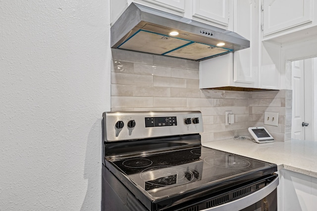 kitchen featuring white cabinetry, decorative backsplash, and stainless steel electric range oven