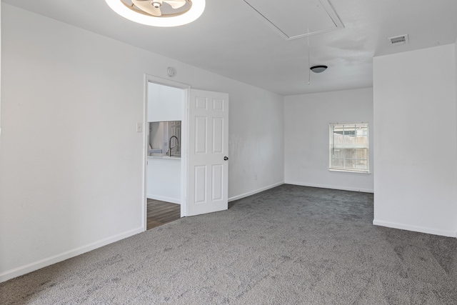 unfurnished room with sink and dark colored carpet