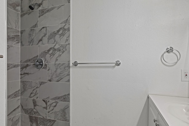 bathroom with vanity and a tile shower