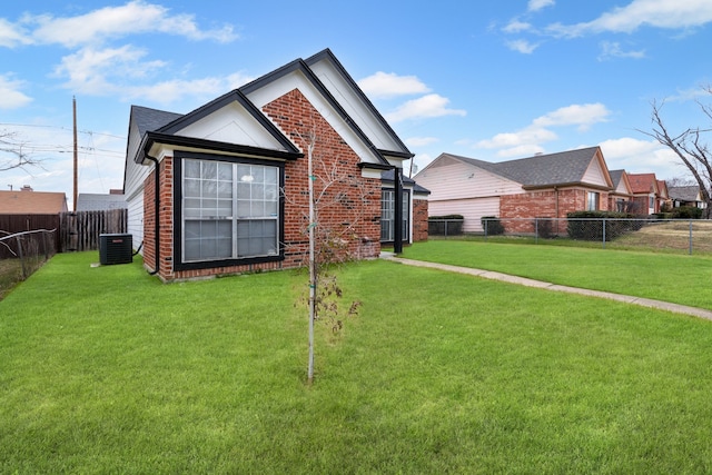 rear view of property with central air condition unit and a lawn