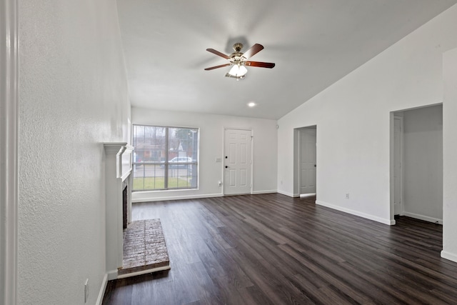 unfurnished living room featuring lofted ceiling, a brick fireplace, dark hardwood / wood-style flooring, and ceiling fan